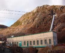 Exterior view of the Petty Harbour Hydro-Electric Generating Station, December 2005, showing surge tank to the top right.; HFNL 2005