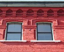 This photograph illustrates the projecting cornice, the decorative brick design, as well as the style and proportion of the windows. 2004; City of Saint John