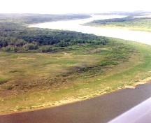 Aerial view looking north at site area on left bank of the South Saskatchewan River, near side of trees, 1999.; Margaret Kennedy, 1999.
