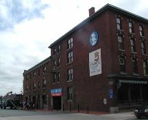 Robertson's Hardware & Warehouse, north side view from Lower Water Street, large warehouse doors, paired windows, bracketed eaves, Halifax, Nova Scotia, 2005.; Heritage Division, NS Dept. of Tourism, Culture and Heritage, 2005.