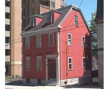 Story-Wilson House, Side elevation showing truncated gable roof and large apartmetn in backgound, Halifax, Nova Scotia, 1997.; HRM Planning and Development Services, Heritage Property Program, 1997.