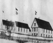 Historic view of St. Peter's Lodge SUF #12 building (left), Fishermen's Protective Union building, and Loyal Orange Lodge along Main Street, Twillingate, Newfoundland, possibly circa 1930.; HFNL 2006