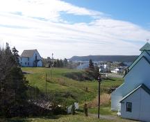 View of the Presentation Convent Grounds, Renews, NL. Covent was located on raised section, adjacent to the rectory on the left. Photo taken May 2006. ; HFNL/Andrea O'Brien 2006