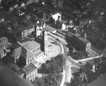 Aerial view of the Basilica of St. John the Baptist and the Basilica Archway.  Other ecclesiastical buildings can also be noted in the picture.  Archway is located near the center right.  Date of photo unknown.; City of St. John's Archives 2006
