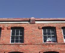 This photograph shows the cornice and two upper storey windows, 2004; City of Saint John