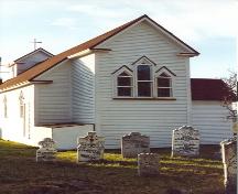 Gable end view of St. Luke's Anglican Church with headstones in foreground, some dating to the 17th century.; HFNL/ 2006