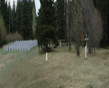 Photo panoramique illustrant quelques vieilles pierres tombales ainsi que celles installées en 1992 pour commémorer les Mi'kmaq enterrés là.; La Société historique de la Valleé de Memramcook