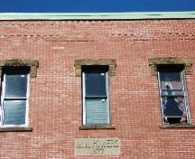 Powers Building - This photograph shows the date stone, upper storey windows, and roof-line, 2005; City of Saint John