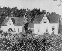 Image of the south side of the Reid Stewart Home showing the original building (right) and the first addition of storage area, summer kitchen and connecting milk shed.; Restigouche Regional Museum, Dalhousie