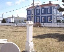 View of Loyal Orange Lodge monument in Frazer Park acknowledging the loss of the Nellie Harris and Tubal Cain with Fidelity Masonic Lodge in the background, Frazer Park, Grand Bank, NL. ; HFNL/Robert Parsons 2007