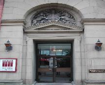 This photograph shows the recessed entrance, pediment and the artistic sculpture upon the pediment, 2004; City of Saint John