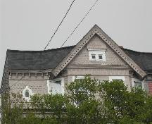 This photograph shows the peaked roof, the scalloped shingling and the oval oculus window, 2005; City of Saint John