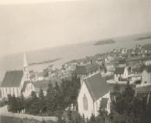 View of Elliston from Lodge Hill, with St. Mary's Anglican Church in the foreground, showing right and rear of the building and the cemetery in front of the church, circa 1950 ; Tourism Elliston Inc., 2007