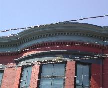 This photograph shows the curved portion of the cornice, as well as the metal and brick dentils, 2005; City of Saint John