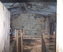 Interior photo view of the Tom Porter Root Cellar, Elliston, NL, 2007; showing steel beam from the "Eric" 1870s shipwreck used in construction; Tourism Elliston Inc., 2007