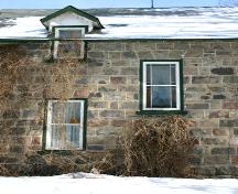 View of the granite fieldstone walls and stained glass window detail, on the west elevation, of the McElroy House, Morden, 2005; Historic Resources Branch, Manitoba Culture, Heritage and Tourism, 2005