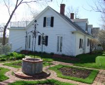 This photograph shows the well with wrought iron cupola at the centre a formal garden. The east side of Cory Cottage is in the background, 2007; Town of St. Andrews