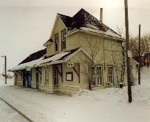 Vue en angle de l'ancienne gare du Chemin de fer Canadien du Nord, montrant les façades du devant et du côté, 1991.; Parks Canada Agency/Agence Parcs Canada, Murray Peterson, 1991.