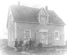 Vue de la maison du côté nord-est, photo prise vers 1915. Agapit Albert, sa famille et quelques voisins. ; Fidèle Thériault Collection
