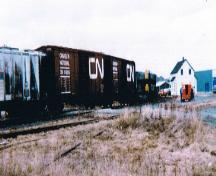 View of a train pulling into the station (seen at the right of the photo). Picture taken circa 1980s.; HFNL 2007