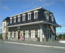Corner view, showing the facade and a side of the Belleville railway station, 1990.; Parks Canada Agency/ Agence Parcs Canada, 1990.