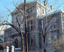 A stern, Italianate-style structure, built of grey Gloucester limestone from 1870-1871; City of Ottawa 2005