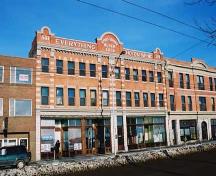 This  image illustrates the front, south-facing primary facade of the building looking from the southwest. The adjacent, historic Lodge Hotel is visible on the right.; City of Edmonton, 2004