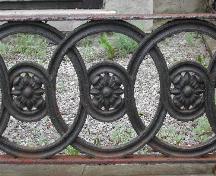 This image shows the circular floral design of the stone and cast iron fence around the front lawn that reflects the pattern specifically created for the Girl Guide cookies, 2005.; City of Saint John