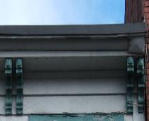 This image provides a view of the  wood cornice supported by scrolled brackets, 2005.; City of Saint John