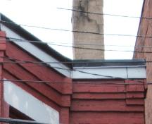 Cette image montre la corniche en pierre et en brique avec une bande d'encorbellement en brique, 2005.; City of Saint John
