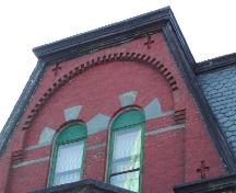 This photograph shows the large dormer with roman arch openings and dentils, 2005; City of Saint John