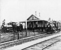 Vue de la première gare ferroviaire avec deux locomotives à vapeur, vers 1880; McAdam Historical Restoration Committee