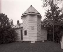 General view of the William Brydone Jack Observatory, showing its simple functional design consisting of a short octagonal tower topped with a conical roof, 1992.; Agence Parcs Canada / Parks Canada Agency, 1992.