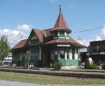 View of the Acton Vale Railway Station Grand Trunk), showing the low massing under a lively roofline including gables and a turret, 2002.; Agence Parcs Canada / Parks Canada Agency, 2002.