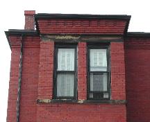 This photograph shows the corbel bands at the cornice and the upper storey windows of the bay, 2005; City of Saint John