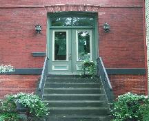 This photograph shows the elevated entrance to the residence, and illustrates the paired doors, transom window and steps, 2005; City of Saint John