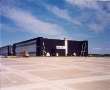 Vue du hangar 7, qui montre les grandes surfaces dégagées formées par les aires de trafic et les voies de circulation asphaltées, 1992.; Department of National Defence / Ministère de la Défense nationale, 1992.