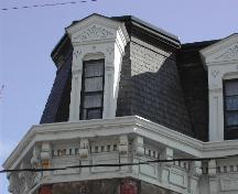 This photograph shows the bracketed roof-line cornice and dormer window, 2005  ; City of Saint John