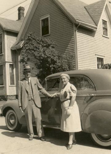 Couple posing with house in background, c. 1945