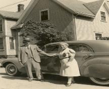 Couple posing with house in background, c. 1945; MacNaught Archives Acc. 063.1