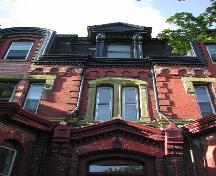This photograph shows the middle of the front façade and illustrates the brick Roman arch motif, the pedimented dormer, and the double-set window, 2005; City of Saint John