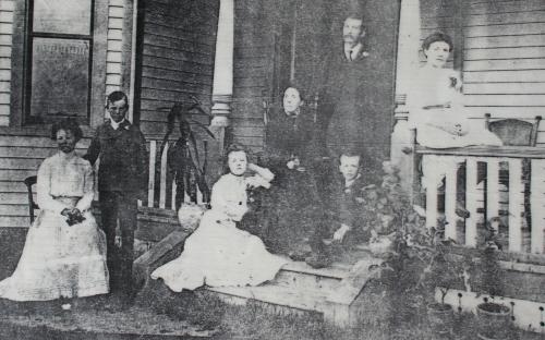 The Morson family posing near their house, c. 1910