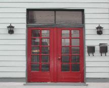 This image shows the two paned transom window over the Craftsmen style paired wood doors with multiple glass panels, 2005; City of Saint John
