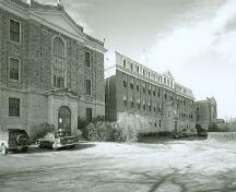 View of the Convent of Jesus and Mary, part of the Gravelbourg Ecclesiastical Buildings National Historic Site of Canada, showing its large brick façade and mansard roof with dormers.; Parks Canada Agency / Agence Parcs Canada