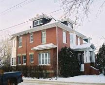 This image illustrates the two-storey east and north brick-clad facades of the George Durrand Residence with prominent Edwardian-era features such as symmetrical composition and classically influenced front veranda.; City of Edmonton, 2004