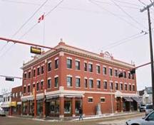This image illustrates the overall form and massing of the Hull Block, in its prominent corner location. Also illustrated are the prominent name plaques in the arched pediments on the two prominent facades. (2004); City of Edmonton, 2004