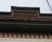 Cette image montre le parapet au-dessus du toit faiblement incliné et la large corniche soutenue par des consoles, 2005; City of Saint John