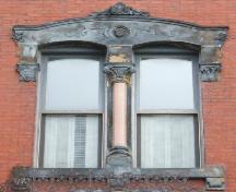 Cette image montre l'une des fenêtres doubles à arche segmentée séparée par une colonne corinthienne et présentant un entablement élaboré et un appuis en grès, 2005; City of Saint John
