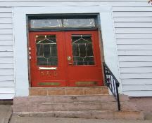 This image provides a view of the entry with the two paned transom window above paired doors, 2005; City of Saint John