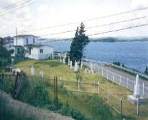 View across First Anglican Cemetery and War Memorial Site, Arnold's Cove, NL, towards the ocean, circa 1995; Courtesy of Iris Brett, 2008